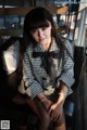 A woman sitting on top of a black and white couch.