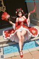 A woman in a red and white dress sitting by a pool.