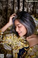 A woman laying on top of a bed next to a curtain.