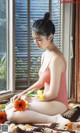 A woman sitting on a bed holding a bunch of flowers.