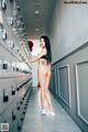 A woman standing in front of a bunch of lockers.