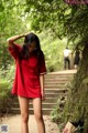 A woman in a red shirt is walking down some steps.